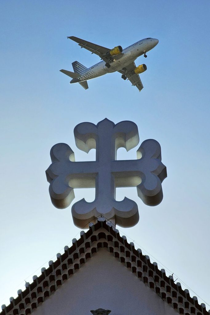An Airplane flying over a cross