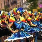 Multiple people in colorful dresses in a parade