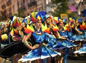 Multiple people in colorful dresses in a parade