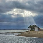 Godrays falling on a house on the beach