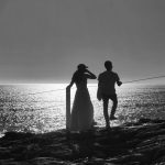 Black and white Silhouette of a couple in front of the sea