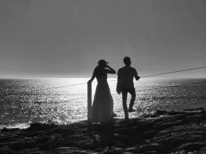 Black and white Silhouette of a couple in front of the sea